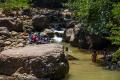 Mujeres lavando la ropa mientras los niños se bañan en el río Shilcayo, Tarapoto.