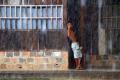 Vecino en la puerta de su casa mientras llueve en Lagunas.