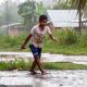 Descripción: Un niño juega bajo la lluvia en Lagunas.